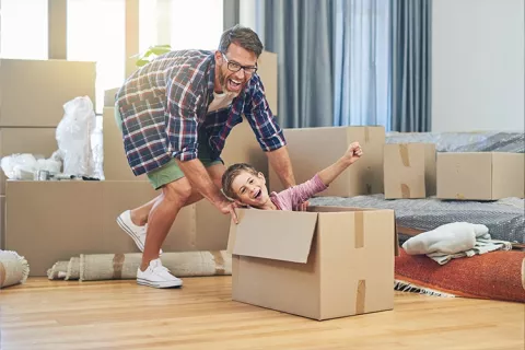 papá e hijo jugando en su vivienda propia gracias al crédito hipotecario Colsubsidio