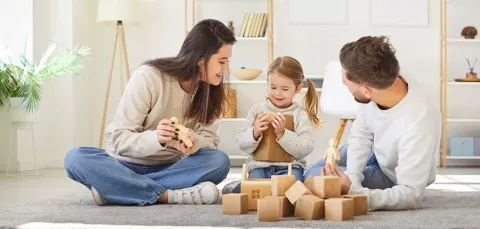 Familia jugando en la sala de su nueva casa adquirida con Colsubsidio.