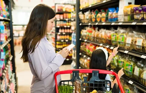 Mamá e hija realizando compra de alimentos gracias al bono lonchera de Colsubsidio.