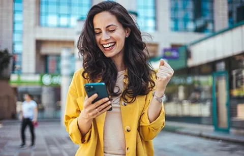 Mujer feliz con su nuevo carné de afiliación a Colsubsidio
