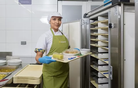 Mujer llevando alimentación a paciente en hospital.