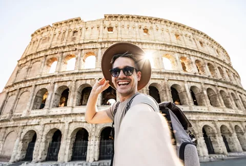 Hombre feliz en el coliseo Romano y tranquilo con la asistencia de viaje Colsubsidio.