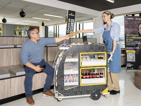 Trabajador comprando snacks en el carro vending de Colsubsidio