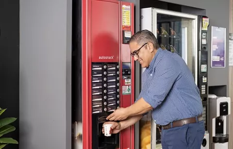 Hombre comprando café en las máquinas vending Colsubsidio.