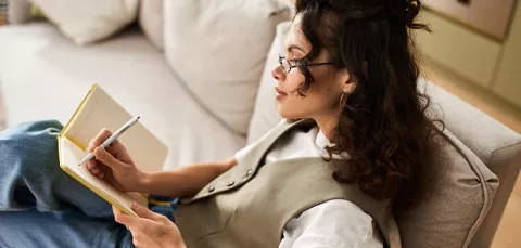 Mujer en sillón escribiendo propositos