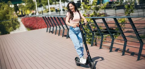 Mujer conduciendo su scooter eléctrica por las calles.