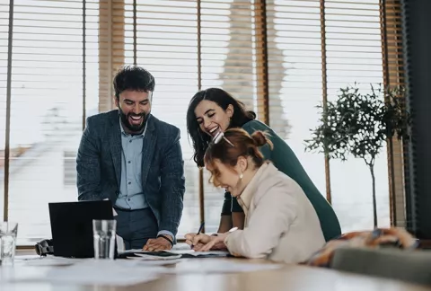 Personas felices en una oficina conocen los programas de Bienestar Colsubsidio para empresas.