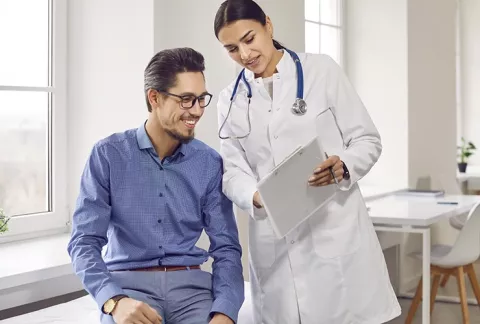Doctora realiza chequeo médico a trabajador en consultorio.