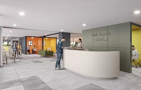 El coworking del conjunto Eskala muestra a personas conversando y trabajando.