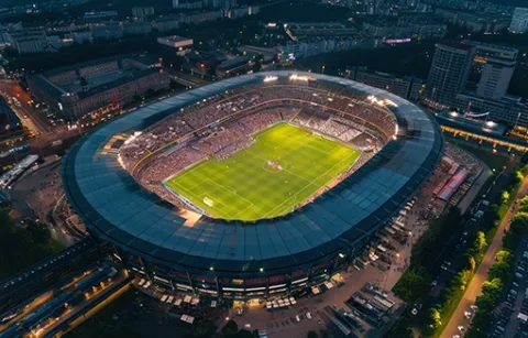 Vista panorámica de un estadio de fútbol iluminado durante un partido de futbol