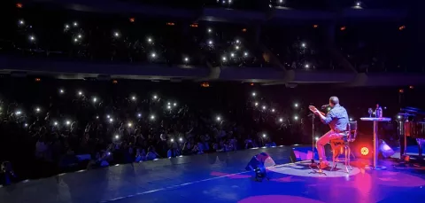 Artista en el escenario del Teatro Colsubsidio interpreta en vivo una canción con su guitarra.