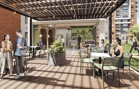 Cafetería del conjunto Zefiro muestra espacio abierto con mesas, plantas y personas.