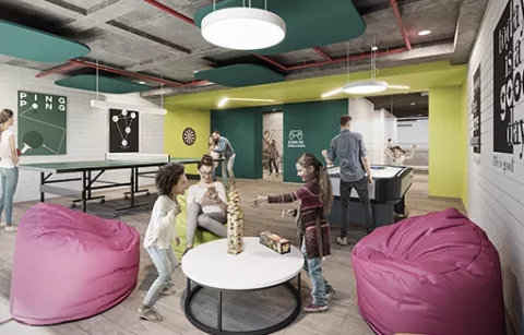 Zona de juegos de Zefiro muestra a niñas jugando jenga y adultos ping pong.