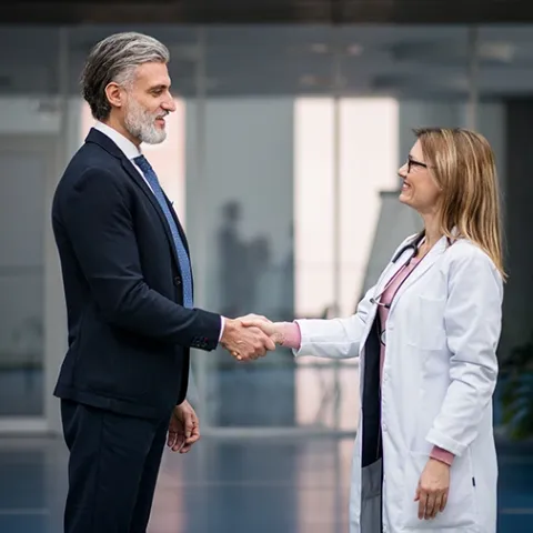 Ejecutivo sostiene la mano de directora médica