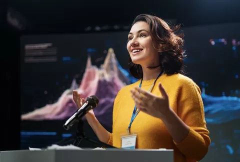 Mujer explica proyecto empresarial en un evento.