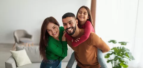 Familia sonríe en la sala de su vivienda.