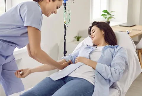 Enfermera pone suero a mujer