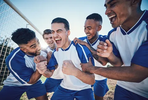 Hombres celebran gol en el torneo fútbol Colsubsidio.