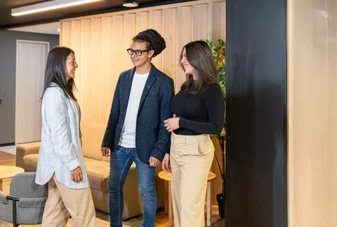 3 empleados de Colsubsidio conversan en espacios renovados.