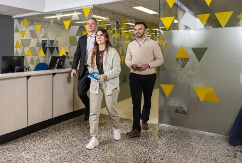 3 empleados de Colsubsidio caminan por las instalaciones de la sede calle 26.