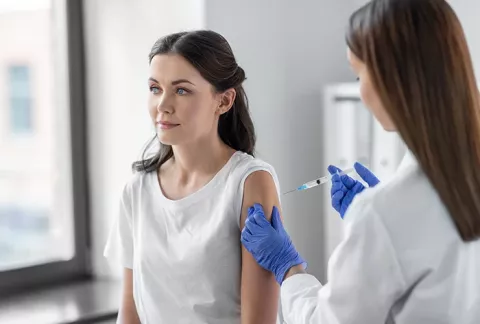 Mujer recibe vacuna de la influenza en Salud Colsubsidio.