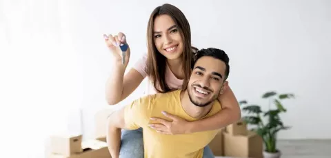Pareja feliz sostiene las llaves de su nueva vivienda Colsubsidio.