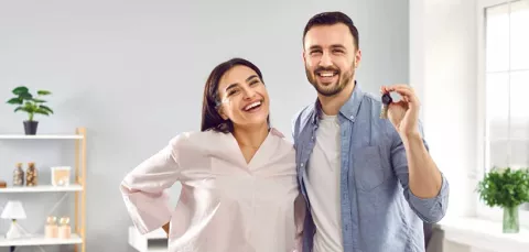 Pareja sostiene las llaves de su vivienda adquirida con Colsubsidio.