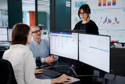 Trabajadores estudian Excel intermedio y datos.