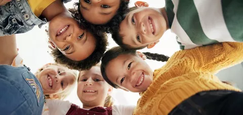 Grupo de niños se abrazan mientras celebran su día en Colsubsidio