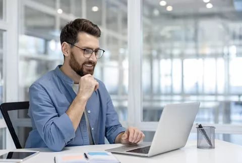 Hombre en su portátil lee información sobre línea ética