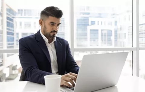 Hombre en su portátil realiza registro de su denuncia en la línea ética.