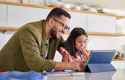 Papá realiza tareas con su hija en la tablet.