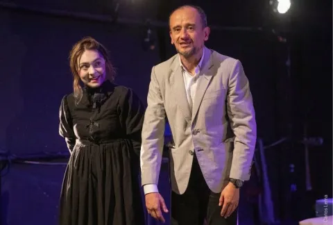 Están parados en un escenario con un hombre y una mujer