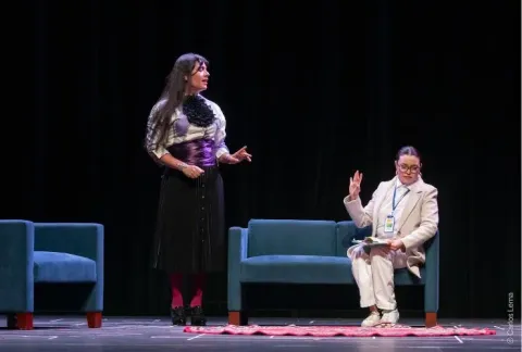 Una mujer con un vestido negro y un hombre con traje blanco y corbata.
