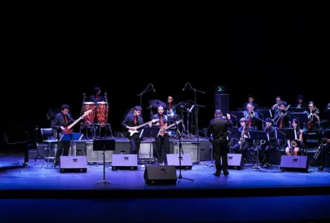 Orquesta actuando en el escenario con instrumentos e instrumentos en el escenario.