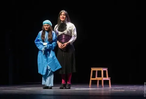 Mujer y una niña de pie en un escenario