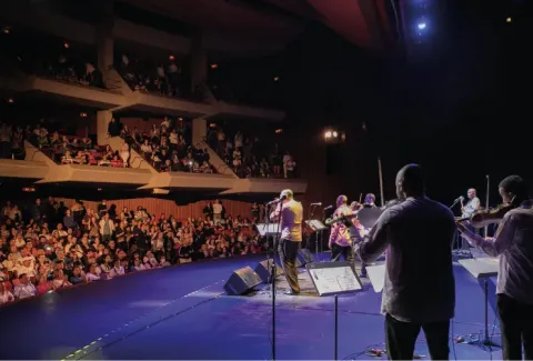 Vista de un concierto con una gran orquesta al fondo.