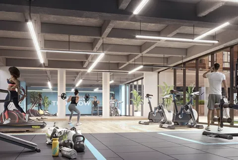 Gimnasio de Nuva Park muestra  personas entrenando en caminadora y zona de pesas