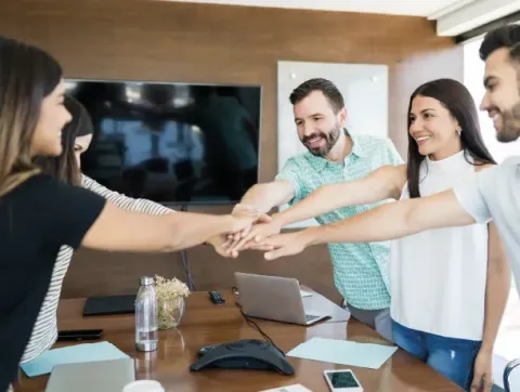Varias personas se dan la mano en una sala de reuniones