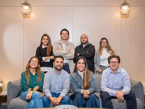 Empleados de Colsubsidio se reunen y sonríen en oficina