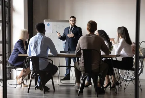 Persona facilitando un taller frente a un grupo, curso Facilitador de Cambio.