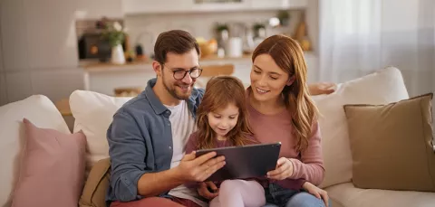 Familia lee una historia en su tablet desde la biblioteca Colsubsidio