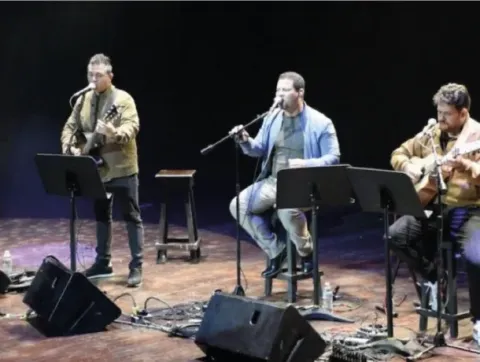 Hombre con barba tocando una guitarra en el escenario