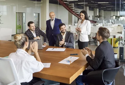 Grupo de personas en una reunión alrededor de una mesa, curso Estrategia Competitiva.