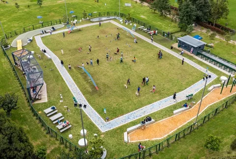 Zona recreativa del parque canino en el Club Bellavista con perros interactuando en el césped.