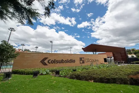Fachada del Club La Colina con áreas verdes y espacios deportivos.