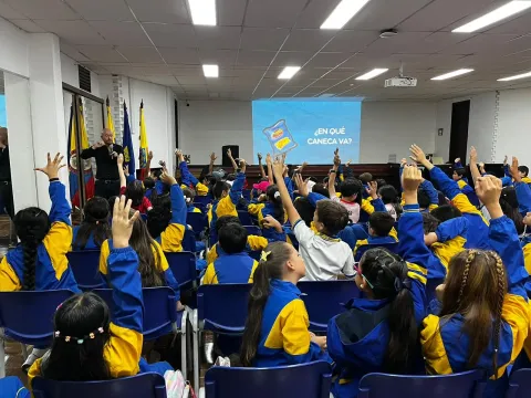Estudiantes de un colegio de Colsubsidio levantan la mano en un taller de separación de residuos. (