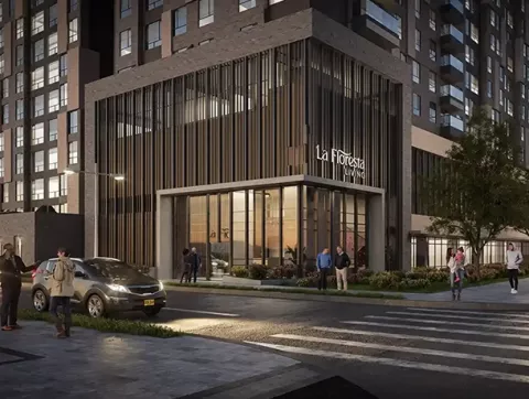 Fachada de Floresta Living muestra portería, vías y personas caminando