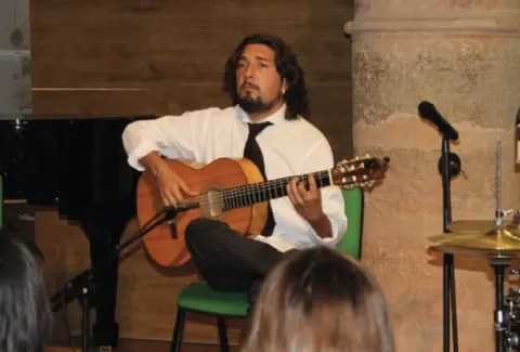 Un hombre que toca una guitarra en una habitación