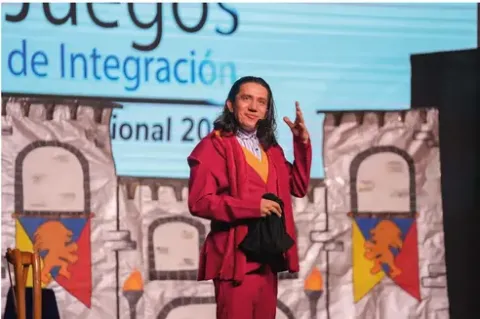Presentador de Teatro Colsubsidio en traje rojo gesticula en escenario temático de castillo.